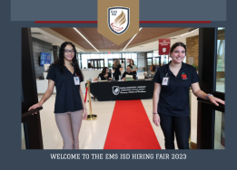  Two HCTC employees standing at open doors of red carpet leading to Hiring Fair registration desk
